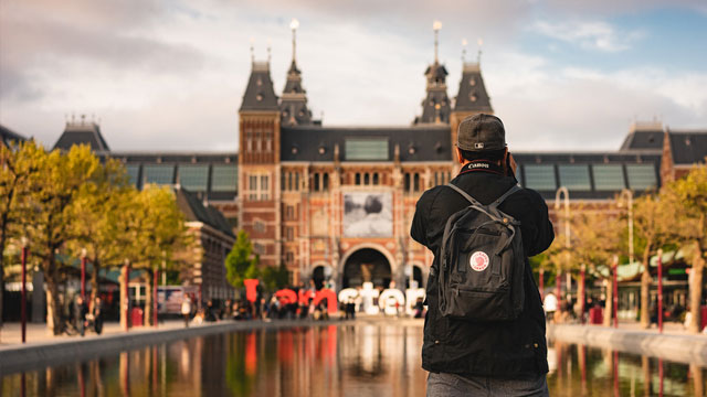 Foto van een toerist voor Het Rijksmuseum in Amsterdam 